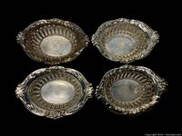 Top view of all four sterling silver nut cups showing monogram 'T' in center and decorative pierced lattice sides.