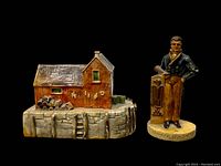 Photo on black background showing the Motif #1 dockside building and the Yankee Ship Captain figurine clearly, illustrating details and scale.