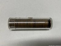Roll of coins stored in clear cylindrical plastic container on white background