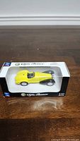 Yellow 1/43 die-cast Alfa Romeo SC 2900 in original packaging on wooden surface