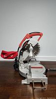 Airco 8 1/4 inch compound mitre saw side view showing blade, handle and dust bag on the left side.