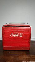 Front view showing red cooler with horizontal stripes and Drink Coca-Cola logo