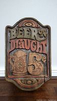 Full front view of the carved wooden Beer On Draught sign showing detailed lettering and paint colors.