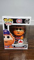 Front view of the boxed Youppi! Funko Pop figure showing the character inside and branding details on box.