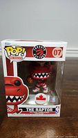 Front view of Funko Pop NBA Mascots The Raptor figure in original box