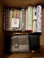 Box containing assorted unused 6-ring journals and binders with floral and textured covers and assorted dividers