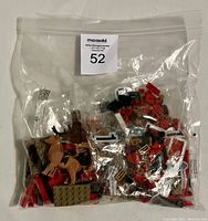 Two clear plastic bags of Lego spare parts, majority opened, containing various individual bricks and figures relevant to Lego set 40499 Santa's Sleigh