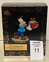 Box for Disney Sketchbook ornament set featuring Mickey Mouse holding a gift, titled 'Pluto's Christmas Tree'. Shows front of the box with Disney branding and decorative gold line art.