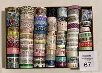 Top view of 78 rolls of washi tape arranged in several rows showing various patterns and sizes