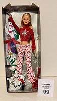Full view of the Barbie doll in box showing her outfit and attached Coca-Cola holiday gift tags.