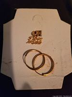 Photo of 10K gold charm 'I Love Mom' with heart and pair of small hoop earrings on white display card.