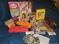 Overview of all arts and crafts items in the lot, including kits, colored pencils, glue, string, and containers