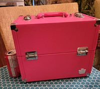 Side view of bright pink Caboodles makeup storage box with chrome latches, handle, and metal corners. Coca-Cola can included for size comparison.