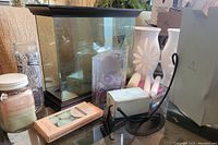 Lot including glass aquarium style candle holder, white ceramic vase, black metal candle holder, assorted candles in jars and packages