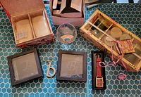 Overview of all lot contents including musical trinket box with soap, two glass letter blocks, two clear glass cups, and boxed watch.