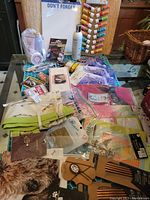 Wide view of the assorted items including stationery, personal care products, hair accessories, jewelry, and small bags on a table surface.