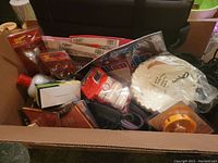 Box showing a variety of items including halogen bulbs, hair care product, coffee filters, toys, and LED bulb box.