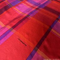 Close-up of scarf showing vibrant red, pink, purple, and orange plaid pattern and Liz Claiborne brand name