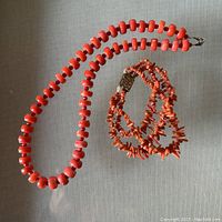 Both necklace and bracelet laid flat on gray background