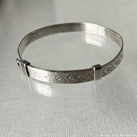 Clear image of sterling silver adjustable bangle showing geometric pattern and clasp mechanism.