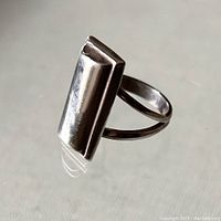 Modern sterling silver rectangular chicklet ring shown at various angles highlighting its polished smooth surface and split band design.