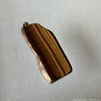 Front view of the rectangular Tigers Eye pendant showing polished stone and natural striped patterns.