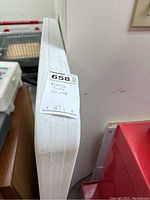 Side view of the folded resin table showing the sticker with dimensions and folding note.