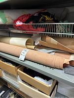 Photo of leather remnants stored on metal shelving, showing rolled and loose sheets in different colors and thicknesses.