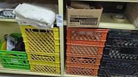 Shelves with yellow, orange, green, and black plastic crates filled with various painting and drywall supplies.