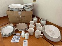 Full set of Royal Doulton crockery pieces displayed with box and note. Includes plates, bowls, cups, salt and pepper shakers, sugar pot, creamer, and platters.