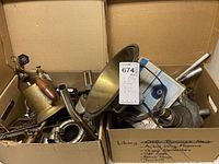 Cardboard box containing brass lamp parts, chrome rods and boxed model car