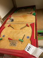 Full view of the vintage wooden table hockey game showing playing surface, handles, nets, and condition.