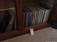 Shelf with approximately 40 assorted vinyl LPs stored upright