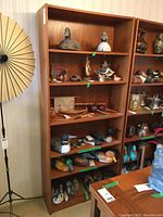 Full front view of six-shelf teak veneer bookshelf loaded with decorative items