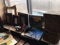 Vintage Kiev camera, photo frames, photo albums, and woven baskets displayed on a window ledge