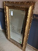 Full front view of the mirror leaning against wall showing overall frame and mirror surface