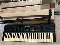 Full image of Kawai FS650 keyboard showing keys, control panel and speakers with the metal stand beside it.