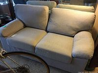 Front three-quarter view of grey loveseat with seat and back cushions
