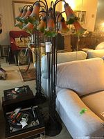 Full view of floor lamp showing the nine glass flower shades and wrought iron base