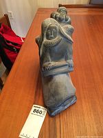 Front view of soapstone carving showing kneeling mother with child on back