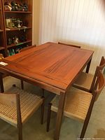 Overall view of teak table with chairs and leaves inserted