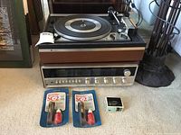 Stacked Noresco turntable atop Quadrasound receiver with cleaning accessories laid out front