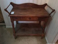 Front view of vintage wooden washstand showing entire piece with drawer and shelf