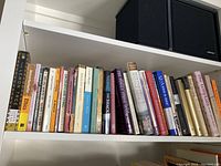 Books arranged on a shelf covering varied subjects from spirituality and ethics to Templars and dying.