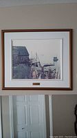 Full image of the framed wall art showing the coastal scene with lupins, wooden structures, and a dock with boats.