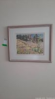 Framed wall art hanging on wall showing entire piece and its frame