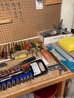 Overview of tools laid out on workbench including screwdrivers, chisels, socket set and pliers.