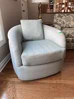 Front view of cloth swivel tub chair showing curved arms and seat cushion.