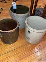 View of three crocks showing different sizes and colors: beige with black numbers, brown glossy crock.