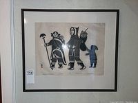 Full view of framed Inuit stonecut print with mat and black frame